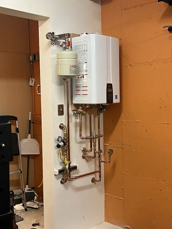 Plumbing technician inspecting water heater connections in Victoria